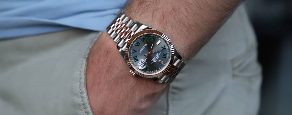 A Rolex watch displayed with a "For Sale" sign in a watch shop.